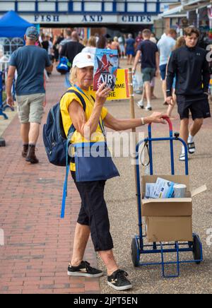 Eastbourne, East Sussex, UK, 20 Sep 2022. A woman sells event programmes for the annual Eastbourne Airshow, one of the largest free events of its kind in the country. Many planes flew, including Spitfires, the Red Arrows display team, the Battle of Britain Memorial Flight and many others. Credit: Andy Soloman/Alamy Live News Stock Photo