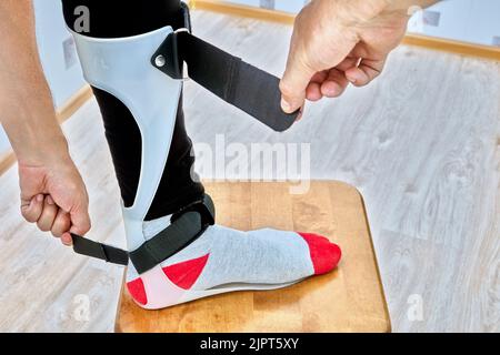 Ankle foot orthosis brace is fixed on leg with velcro straps. Stock Photo