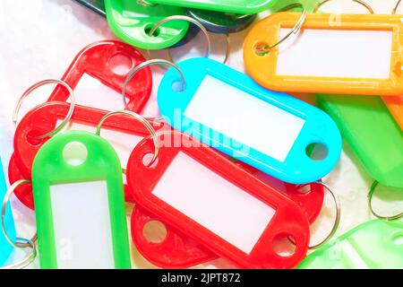 Keychain Plastic key holder in different colors with white background and various papers and a keyboard in the concept of organization and order in co Stock Photo