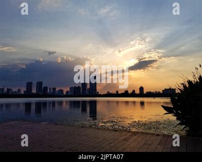 A beautiful view of buildings reflected in Lake Xuanwu during scenic sunset in Nanjing, China Stock Photo