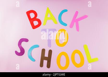 Inscription Back to school with colored letters on a pink background. Back to school concept Stock Photo