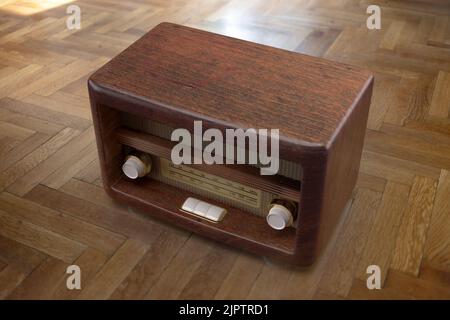 Nostalgia concept. Retro radio on wooden floor background. Vintage old fashioned brown radio for music, news, broadcast. Overhead view. 3d render Stock Photo