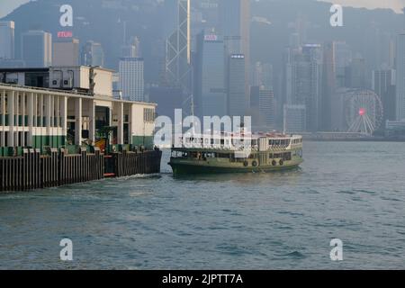 Star Ferry Pier at Tsim Sha Tsui Hong Kong Photo Coloured Star Ferry Green White Ferry Background is Central of Hong Kong Island IFC Stock Photo