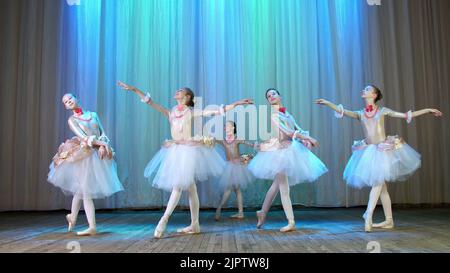 ballet rehearsal, on the stage of the old theater hall. Young ballerinas in elegant dresses and pointe shoes, dance elegantly certain ballet motions, pass, scenic bow. High quality photo Stock Photo