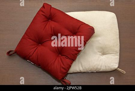 Soft comfortable colorful chair pillows on brown wooden background Stock Photo
