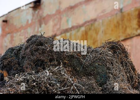 pile of metal swarf on dirty concrete wall background, close-up Stock Photo
