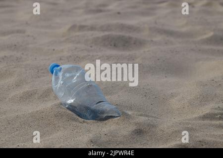 Land and sea pollution, environmental problem, used plastic bottle on the seashore. Stock Photo