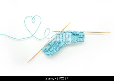 Knitting needles from wool and cotton. knitted product on knitting needles on a white background. Stock Photo