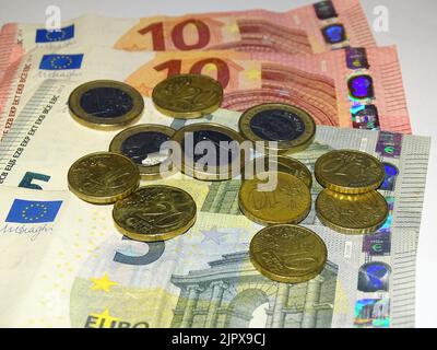 Banknotes, tens, fives and coins in top view and close-up. Stock Photo