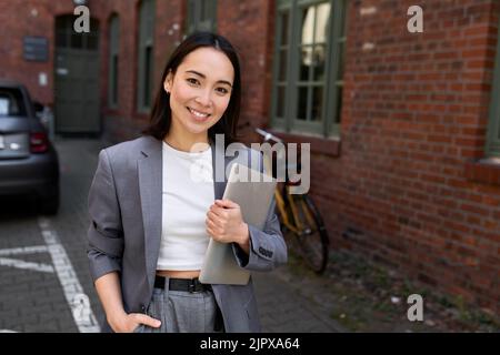 Young professional leader Asian business woman wearing suit, outdoor portrait. Stock Photo