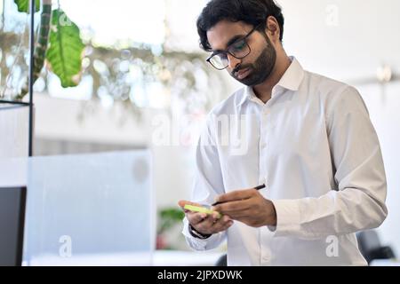 Busy indian professional man executive working in office planning project. Stock Photo