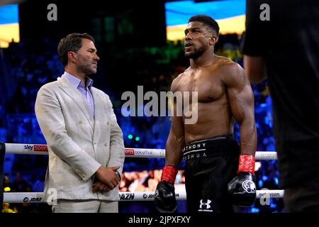 Anthony Joshua (right) and boxing promoter Eddie Hearn during the Ukrainian national anthem, prior to the World Heavyweight Championship WBA Super IBF, IBO and WBO fight against Oleksandr Usyk at the King Abdullah Sport City Stadium in Jeddah, Saudi Arabia. Picture date: Saturday August 20, 2022. Stock Photo