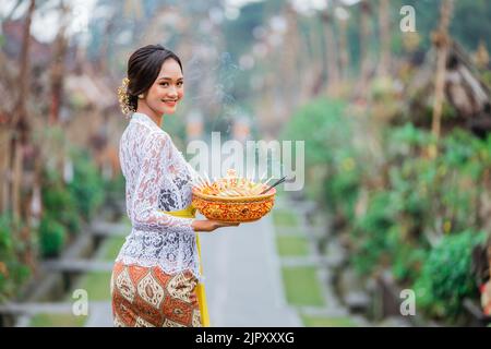 beauty of balinese woman smiling to camera standing in bali village penglipuran Stock Photo