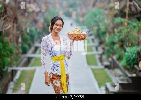 beauty of balinese woman smiling to camera standing in bali village penglipuran Stock Photo