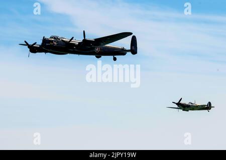 Eastbourne, East Sussex, UK.. 20th Aug, 2022. With the Battle of Britain memorial flight, featuring the Avro Lancaster (top) and Spitfire (below). The flyby at the annual Eastbourne International Airshow viewed from the beach at Eastbourne. 20th August 2022. Credit David Smith/Alamy Live News Credit Stock Photo
