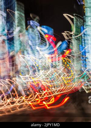 Blurred neon light streaks at night, creating a vibrant, colorful, and dynamic abstract visual effect Stock Photo