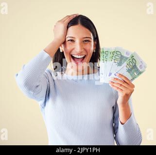 Woman celebrating success, winning money or lottery victory, holding cash or banknotes in hand. Portrait of excited, happy and proud winner screaming Stock Photo