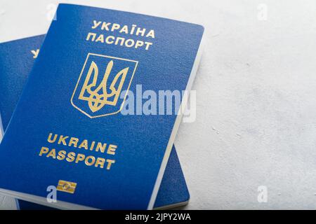 Two blue biometric passports of citizens of Ukraine on a white background. Close-up. Tourism, business, travel abroad, emigration, Russian aggression Stock Photo