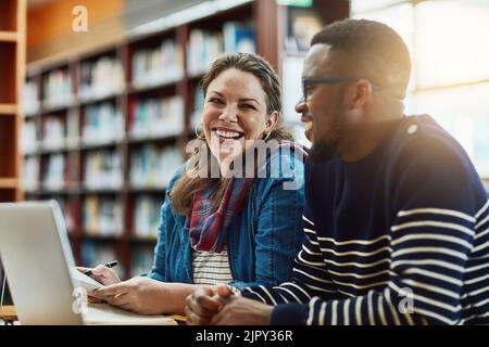 Finals will be a breeze. two university students working together on a laptop at campus. Stock Photo