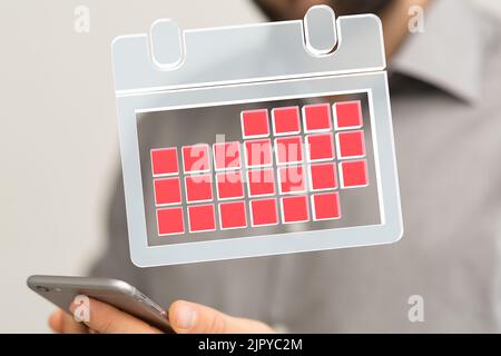 A floating 3D calendar above a hand holding a smartphone Stock Photo