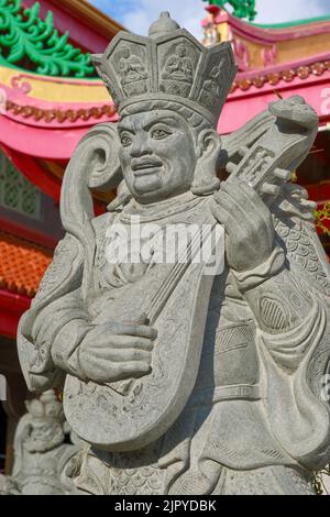A lute playing guardian figure guarding the entrance to (Taoist) Jui Tui Temple in Phuket Town, Phuket, Thailand Stock Photo