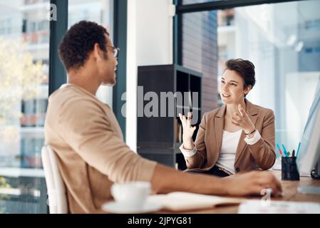 Lets be more strategic about our plans...two businesspeople having a discussion in an office. Stock Photo