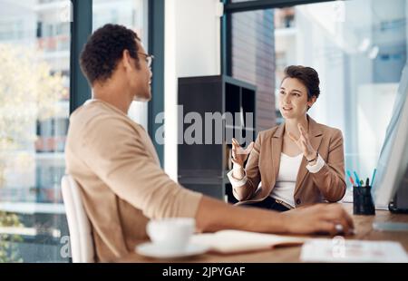 Two heads equals twice as many ideas. two businesspeople having a discussion in an office. Stock Photo