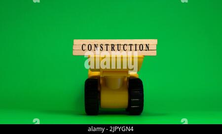The word Construction is written on wooden sticks. Machine concept. job occupations. Stock Photo