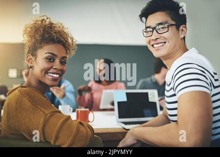 Together, well achieve excellence. Portrait of two young designers sitting in an office. Stock Photo