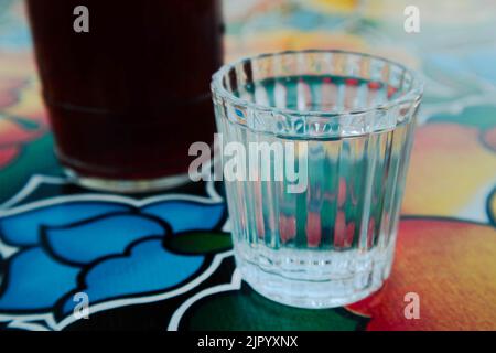 A glass of Mezcal on a table at a bar in Oaxaca City, Mexico Stock Photo