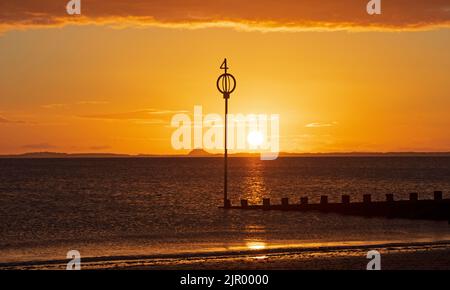 Portobello, Edinburgh, Scotland, UK. 21st August 2022. Cool colourful sunrise with temperature of 12 degrees centigrade, feeling autumnal at dawn for the quiet seaside by the Firth of Forth. Pictured sunrise looking over waterof the Firth of Forh towards Berwick Law in East Lothian. Credit: Arch White/alamy live news. Stock Photo