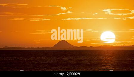 Portobello, Edinburgh, Scotland, UK. 21st August 2022. Cool colourful sunrise with temperature of 12 degrees centigrade, feeling autumnal at dawn for the quiet seaside by the Firth of Forth. Pictured sunrise looking over waterof the Firth of Forh towards Berwick Law in East Lothian. Credit: Arch White/alamy live news. Stock Photo