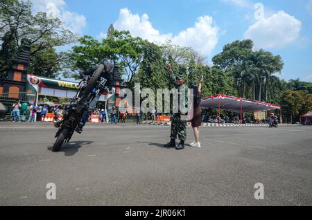 Malang, East Java, Indonesia. 11th Aug, 2022. One of the motorcycle jockeys is exhibiting the tire lifting attraction in the 77th Indonesian Independence Festival at the rampal field, Malang city (Credit Image: © Moch Farabi Wardana/Pacific Press via ZUMA Press Wire) Stock Photo