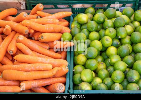 Limes and carrots for sale at a market Stock Photo