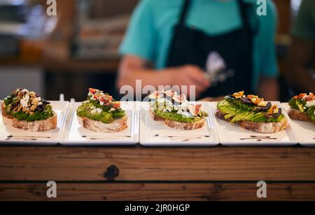 A number of tasty bruschettas served on white plates in a food market in Cape Town, South Africa Stock Photo