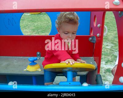 two year old boy having a good time in a park Stock Photo