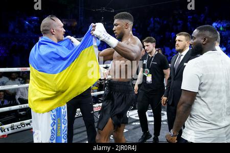 Anthony Joshua takes the Ukrainian flag off the shoulders of Oleksandr Usyk after losing the World Heavyweight Championship WBA Super IBF, IBO and WBO fight at the King Abdullah Sport City Stadium in Jeddah, Saudi Arabia. Picture date: Saturday August 20, 2022. Stock Photo