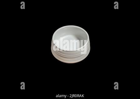 Isolated Ceramic mug of tea, made of white clay, on black background. Stock Photo