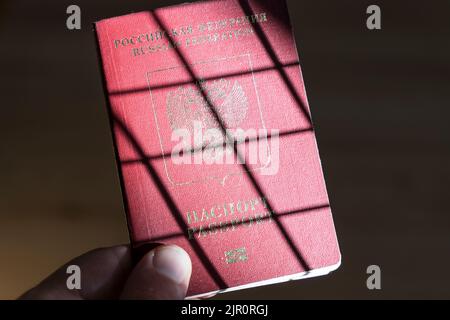 Russian foreign passport in the hands of a man. Prohibition of Schengen visas for Russian tourists to travel to the European Union concept. High quality photo Stock Photo