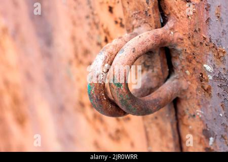 Iron hinges for a padlock on a metal door with old cracked paint and rust. Texture and background Stock Photo
