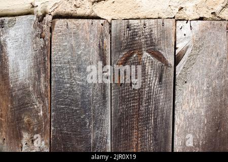 Old cob wall with cracked surface and old wooden boards. Vintage background for design purposes Stock Photo
