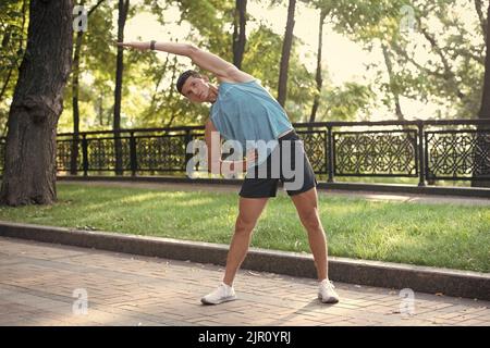 active man in sportswear making stretching exercise Stock Photo