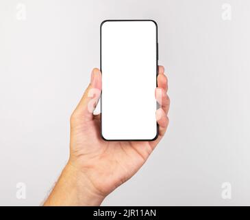 Hand holding phone in vertical position. Woman using for taking Selfie. Smartphone template with empty display for advertisement. High quality photo Stock Photo