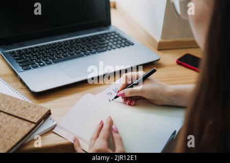 Taskmanager, To do List, Boosts Productivity, Close up of female hands and paper to do list in notepad Stock Photo