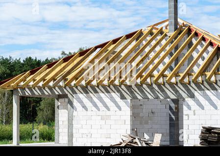 Roof trusses connected to the roof truss, not covered with a roof, with a steel I-beam instead of a corner rafter. Stock Photo