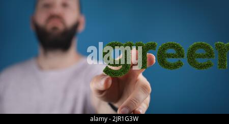 A man tapping a floating 3d-rendered "green" text, the concept of ecology Stock Photo