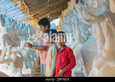Pileru, India - July 28,2022: Kid holding ganesha idols hand. bonding of kids with lord ganesha. Stock Photo