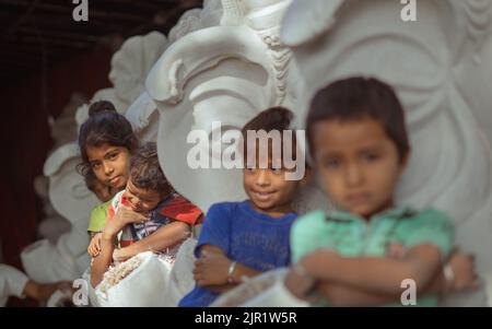 Pileru, India - July 28,2022:Girl holding baby in the hands. baby crying in the hands of girl. Kids in front de-focus. Stock Photo