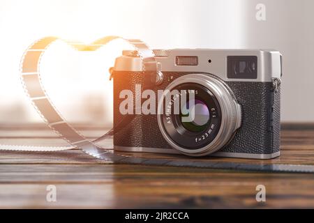 Vintage photo camera and photo film in shape of heart on wooden table. 3d illustration Stock Photo
