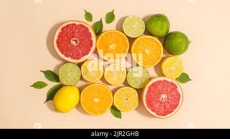 Summer composition of citrus fruits and green leaves on beige background. Flat lay Stock Photo